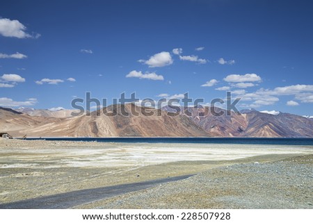 High mountain road beside of deep blue lake