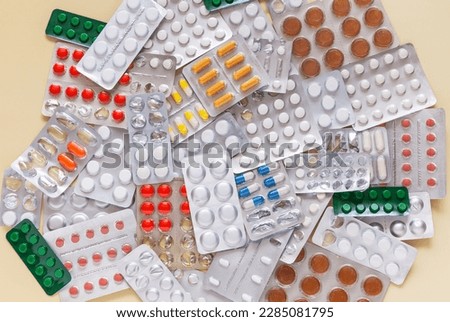 Pile of expired pills and capsules of medicines on the table. Problem of disposal of medicines and plastic packaging. Medical background. Treatment and prevention. Flat lay, close-up, top view, mockup Royalty-Free Stock Photo #2285081795
