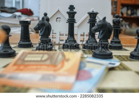euro bills on the chessboard in front of black chess pieces