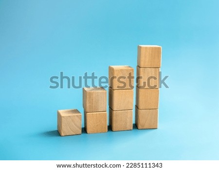 Blank wooden cube blocks bar graph chart steps, isolated on blue background, investment, income, trends, inflation, business growth, economic improvement concepts. Four step eco style wood graph.