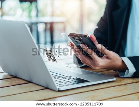 QR Code, multi factor authentication security concept. Digital scanner, graphic symbol on smartphone camera lens holding by businessman hand, scanning for login on virtual screen from laptop computer. Royalty-Free Stock Photo #2285111709