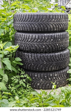 Four good black tires for car on green nature background