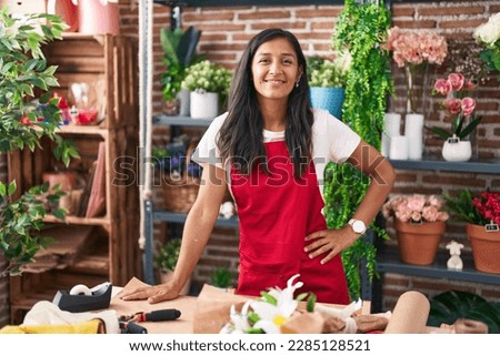 Young beautiful hispanic woman florist smiling confident standing at flower shop Royalty-Free Stock Photo #2285128521