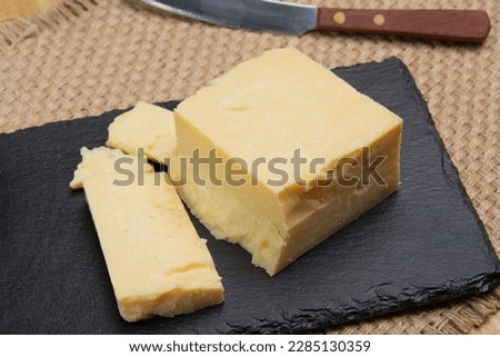 British cheeses collection, English matured smoked cheddar cheese close up Royalty-Free Stock Photo #2285130359