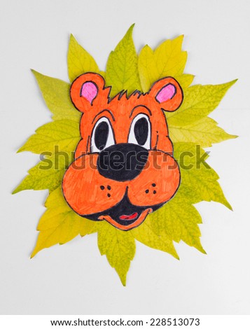 Autumn leaves with painted lion isolated on white