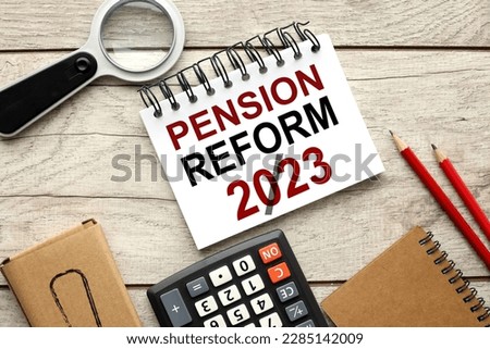 PENSION REFORM concept. wooden background open notepad with text near calculator