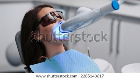 Teeth whitening for woman. Bleaching of the teeth at dentist clinic. Royalty-Free Stock Photo #2285143617
