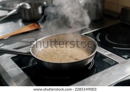 Professional kitchen in the hotel restaurant close-up of chef preparing risotto on the stove Royalty-Free Stock Photo #2285149003