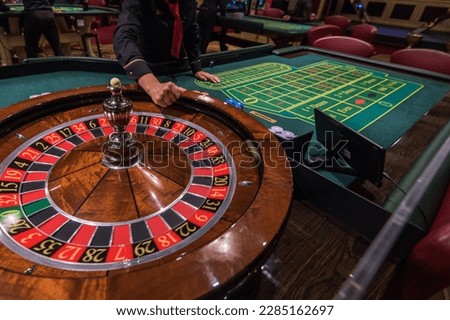 Casino, gambling and entertainment concept - roulette table and stack of poker chips Royalty-Free Stock Photo #2285162697
