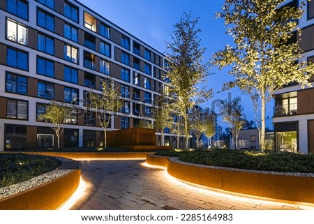 Residential buildings in a European city at night. Modern blocks of flats. Courtyard with vegetation and lighting. Rust metal finish, corten. Underground garage Royalty-Free Stock Photo #2285164983