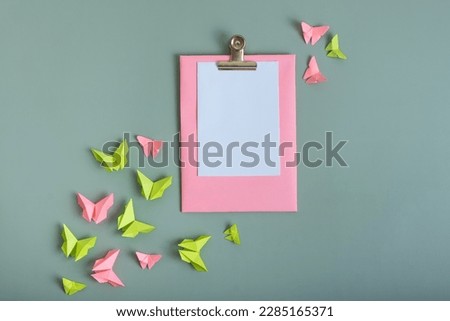 Massage board mockup with paper butterflies green and pink color flat lay on a colored background.