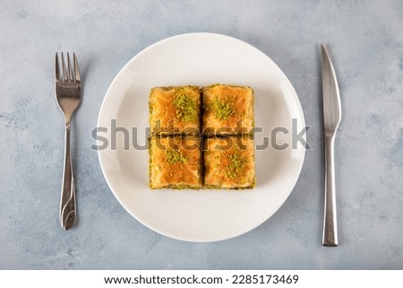 Pistachio Turkish baklava on a white plate,top view Royalty-Free Stock Photo #2285173469