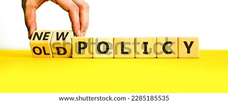 New or old policy symbol. Businessman turns wooden cubes and changes words 'old policy' to 'new policy'. Beautiful yellow table, white background. Business, old or new policy concept. Copy space. Royalty-Free Stock Photo #2285185535