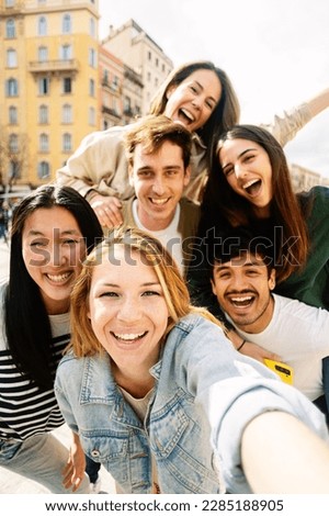 Vertical photo of young group of happy people taking selfie enjoying time together. Multiracial student friends laughing at mobile phone camera photo. Royalty-Free Stock Photo #2285188905