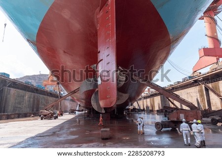 Back view on the container ship. Ship is inside a dry dock for routine maintenance and painting. Royalty-Free Stock Photo #2285208793