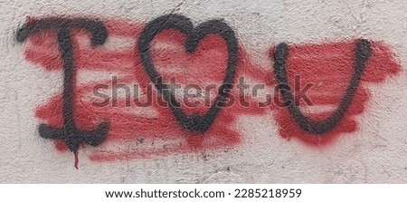 Red painted out over "I love you" and heart symbol message with red ink on white line notebook lie on white wall. Sad and disappointed in love delete “I love you” on Valentine’s day on fence.