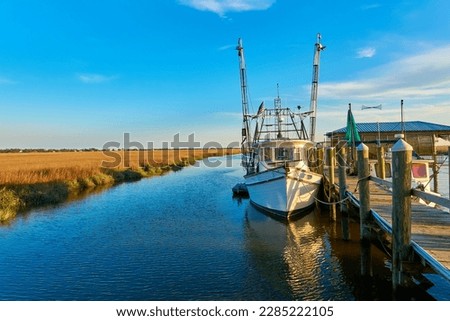 Sunset with shrimp boat along a dock at Tybee Island, Ga. Royalty-Free Stock Photo #2285222105