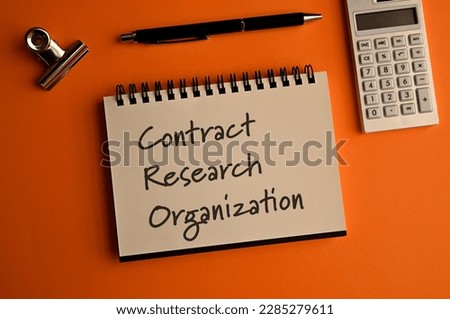There is a notebook with the word Contract Research Organization. It is eye-catching image.