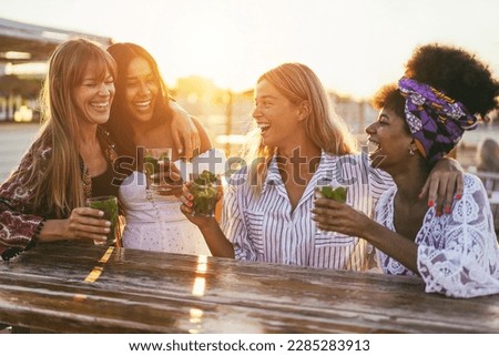 Happy girls having fun drinking cocktails at bar on the beach - Soft focus on center girl face Royalty-Free Stock Photo #2285283913