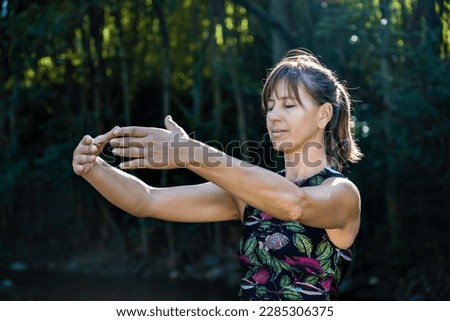Qigong Female Master Practicing Chinese Martial Arts in Nature. Sunlight illuminates the scene Royalty-Free Stock Photo #2285306375