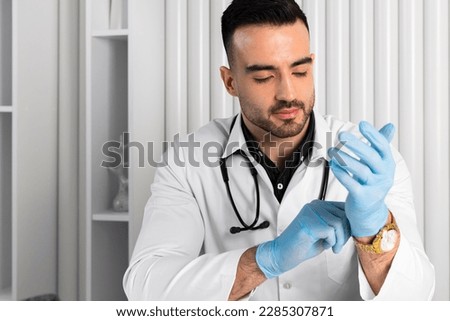 Handsome Doctor wearing clean or sterile gloves.