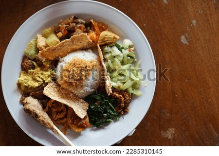 The legendary nasi campur Bali - One of authentic balinese food. Balinese meal of steamed rice with chicken, egg, satay, beef and vegetable. Selective focus on food.
