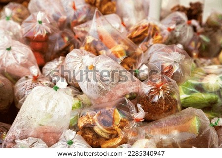 Street food cart with exotic Asian takeaway food in plastic bags. Outdoors food vendor stall on a sidewalk