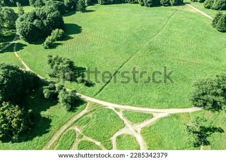 aerial view of summer park landscape with green trees, lawns and walking paths