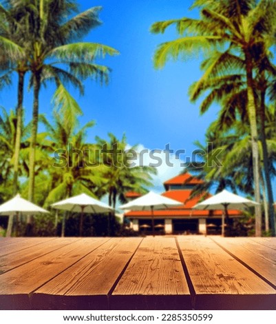 Wood floor or plank table with tropical summer background  resort hotel with patio umbrella and palm tree. Beautiful beach resort and outdoor spa.