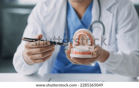 Dentists are discussing dental problems at report x-ray image on laptop screen to patients. Royalty-Free Stock Photo #2285365049