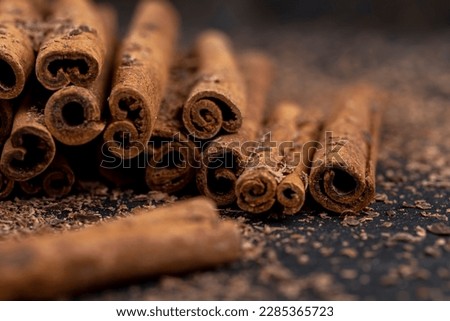 solid aromatic cinnamon on the table in chocolate, chocolate chips and sticks of fragrant cinnamon spice close-up Royalty-Free Stock Photo #2285365723