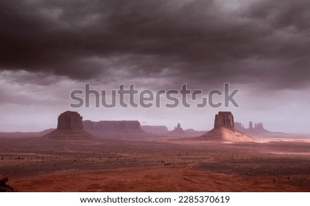 "Monument Valley" - a stunning natural formation of red sandstone buttes, mesas, and spires that rise dramatically from the desert floor, located on the Navajo Nation Reservation Royalty-Free Stock Photo #2285370619