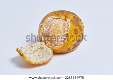 Imperfect or bad skin organic orange which skin partly peeled open exposing the juicy flesh inside, isolated white Royalty-Free Stock Photo #2285384975