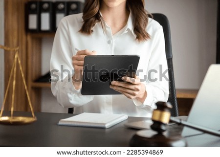 justice and law concept. asian woman lawyer working and judge in a courtroom the gavel, working with tablet and laptop and digital tablet computer 