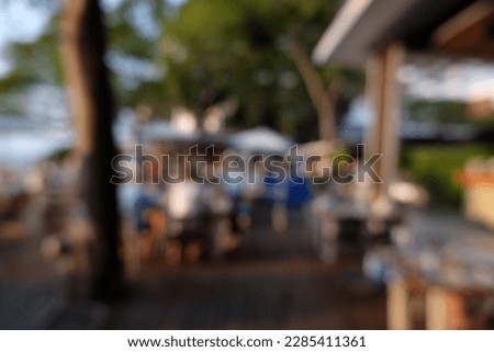 Blur focus of outdoor restaurant near the sea.Blur focus of  cafe terraced area during sunny warm day.