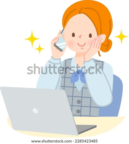 Woman talking on smartphone while operating laptop