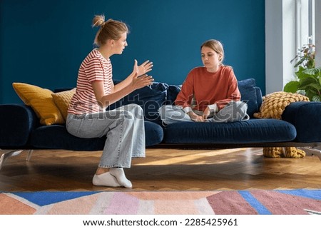 Annoyed woman mom talking arguing with teen girl daughter sitting on couch at home. Psychological puberty and relationships family problem, mutual misunderstanding, motherhood, parenthood concept.  Royalty-Free Stock Photo #2285425961