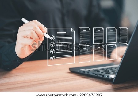 Man using a pen and laptop with touching on virtual screen contact questionnaire with checkboxes. Assessment test concept, fill out application form, online exam, quiz knowledge and online learning. Royalty-Free Stock Photo #2285476987