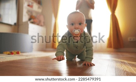 baby learns to crawl on floor at home. happy family a kid dream concept. baby son crawling on the floor first steps. baby newborn learns to crawl on the floor. baby and dad crawl lifestyle Royalty-Free Stock Photo #2285479391