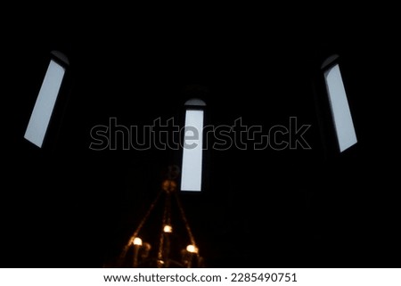 Windows in Church. Three windows on black background. Details of religious building.