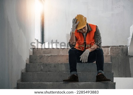Stress engineer or architect holding hands at his head. He is having problems in work. He is sitting on stairs. Engineering concept. Royalty-Free Stock Photo #2285493883