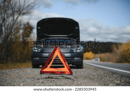breakdown triangle stands near a broken car Royalty-Free Stock Photo #2285503945