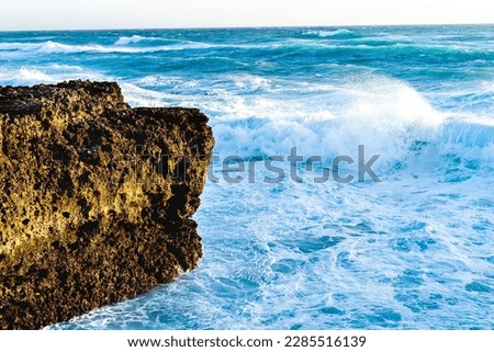 A photo of raging waves crashing into the sea.