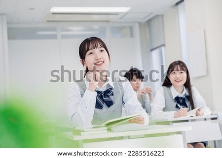 A high school student solving a problem while worrying Royalty-Free Stock Photo #2285516225