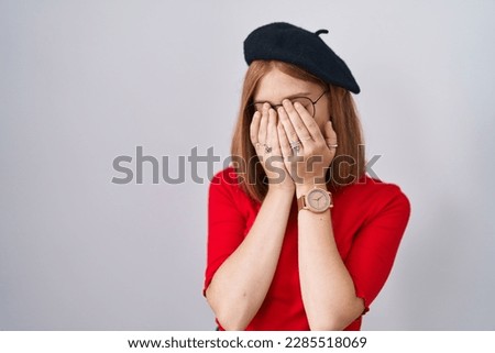 Young redhead woman standing wearing glasses and beret rubbing eyes for fatigue and headache, sleepy and tired expression. vision problem 