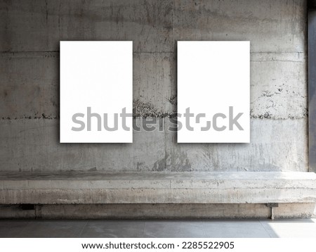 Two white blank rectangle picture frames, vertical style. Couple empty square artist canvas space hanging on concrete wall background over empty cement long bench seat.