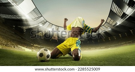 Winner, victory. Professional football player on sport football arena celebrating a goal at 3D model sport stadium arena. Champion, winner emotions. Concept of sport, energy, achievements, success, ad