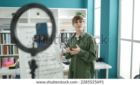 Young caucasian woman recording teaching maths on magnetic board at library university
