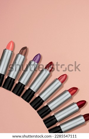 Lipstick makeup concept. Set of red, pink, berry, magenta, purple color lipsticks. Make-up Visage accessories. Background for design with empty copy space