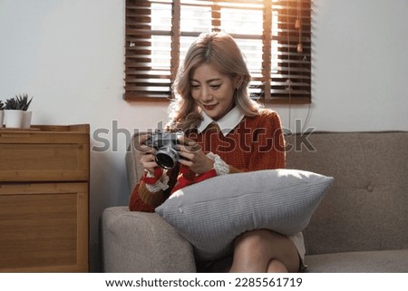 Portrait of pretty young woman looking at pictures from the camera